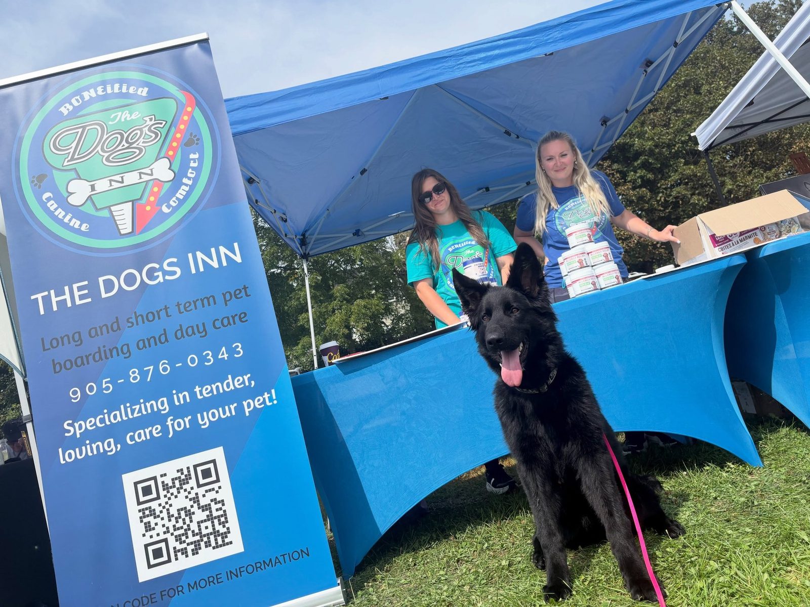 Happy black shepherd at The Dog’s Inn community booth