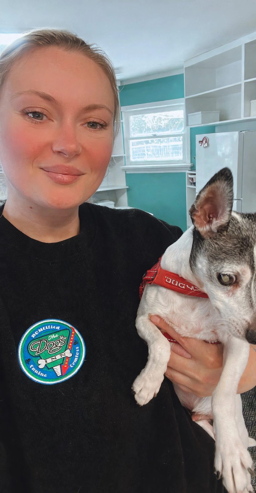 Nadine, owner of The Dog's Inn, holding one of the guest dogs